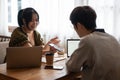 A female is talking and showing something on her phone to a friend while sitting in a coffee shop Royalty Free Stock Photo