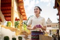 Charming Asian lady in a traditional Thai-Northern dress is visiting a temple on a Buddhist holy day