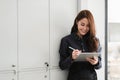 Charming asian woman holding pen stylus writing on ditigal tablet, business financial concept Royalty Free Stock Photo