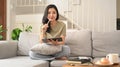 Charming asian woman using digital tablet on couch in cozy living room, enjoying leisure weekend time alone at home Royalty Free Stock Photo