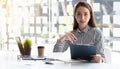 Charming Asian woman working at the office using a taking notes. Looking at the camera Royalty Free Stock Photo