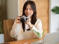 Charming asian young female photographer, content editor holding vintage retro camera