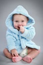 Charming baby in a blue bathrobe