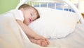 Charming baby falls asleep on white bed in his bed in room at home. concept of sleeping child. child wants to sleep and