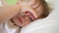 Charming baby falls asleep on white bed in his bed in room at home. concept of sleeping child. child wants to sleep and Royalty Free Stock Photo