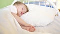 Charming baby falls asleep on white bed in his bed in room at home. concept of sleeping child. child wants to sleep and Royalty Free Stock Photo