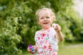 Charming baby girl with soap bubbles in the park or garden