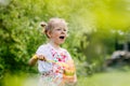 Charming baby girl with soap bubbles in the park or garden