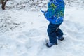 Charming baby little boy digging snow blue small shovel in winter day Royalty Free Stock Photo