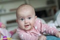 Portrait of a charming baby lying on its stomach and laughing. Family morning at home. Tummy time