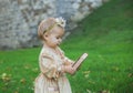 Charming baby in princess costume with a crown on head is carries a wooden box