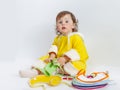 Charming baby in yellow rompers chooses bib