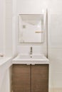 A charming bathroom with a sink and a square mirror