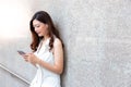 Charming beautiful asian woman. Attractive beautiful girl is listening nice music by using smartphone, earphone at her office Royalty Free Stock Photo