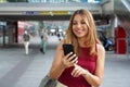 Charming beautiful business woman smile in casual style using smartphone walking in train or metro station