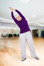 Charming beautiful elderly woman doing exercises while working out playing sports Royalty Free Stock Photo