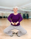 Charming beautiful elderly woman doing exercises while working out playing sports Royalty Free Stock Photo