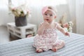 Adorable baby boy in white sunny bedroom plays alone on the bed. Royalty Free Stock Photo