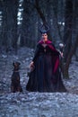 Charming and Beautiful Maleficent Woman with Highbred Dog on Leash. Posing Together in Early Spring Forest