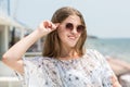 Charming and beautiful young model girl in sun glasses on the sea background. A cute female model. Beautiful girl in sun glasses. Royalty Free Stock Photo