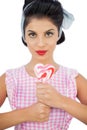 Charming black hair model holding a heart shaped lollipop