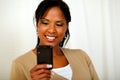 Charming black woman sending message by cellphone