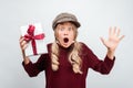 Charming blonde girl with gift posing with surprised face expression. Studio shot white background, isolated Royalty Free Stock Photo