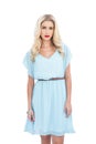 Charming blonde model in blue dress looking at camera