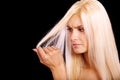 Charming blonde is not happy with fragile hair Royalty Free Stock Photo