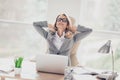 Charming, blonde, pretty woman sitting at desk in workplace, holding hands behind the head, having her eyes Royalty Free Stock Photo