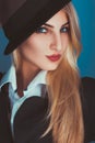 Charming blonde woman in black hat looking at camera Royalty Free Stock Photo