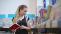 Beautiful girl shopping for stationery.