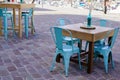 Charming blue steel retro chairs on cafe outdoor restaurant cafe and wooden tables colorful terrace