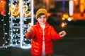 A charming boy holds a sparkler in his hands, celebrating the new year at night on the street. The concept of Christmas Royalty Free Stock Photo