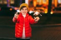 A charming boy holds a sparkler in his hands, celebrating the new year at night on the street. The concept of Christmas Royalty Free Stock Photo