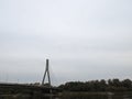 A charming bridge spanning over a serene river, with lush greenery of a forest on the opposite bank