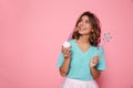 Charming brunette girl with magic wand holding cupkake looking a Royalty Free Stock Photo