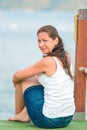 Charming brunette resting sitting on a pier Royalty Free Stock Photo