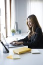 Businesswoman sitting in bright modern office and working with laptop. Royalty Free Stock Photo