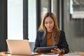 Businesswoman sitting at office desk and checking information on digital tablet. Royalty Free Stock Photo