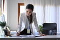 Businesswoman standing at her office desk and checking reports. Royalty Free Stock Photo