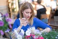 Charming caucasian blonde girl in a blue dress sitting at a table in a city cafe alone and waiting Royalty Free Stock Photo