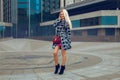 Charming cheerful blonde girl in coat posing outdoors and smiling on the camera