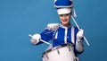 Charming cheerful drummer in a blue uniform, sings and plays the drum.