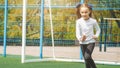 Charming cheerful little girl runs on green grass, playground