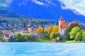 Charming church on lakeside bank of Thun City, on mountain under blue sky background.