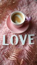 Charming coffee cup with heart-shaped stirrer on a soft pink backdrop Royalty Free Stock Photo