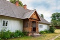 charming country cottage with a shingle roof and a porch and a small garden. Zwierzyniec, Poland