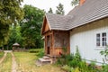 charming country cottage with a shingle roof and a porch and a small garden. Zwierzyniec, Poland