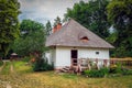 charming country cottage with a shingle roof and a porch and a small garden. Zwierzyniec, Poland